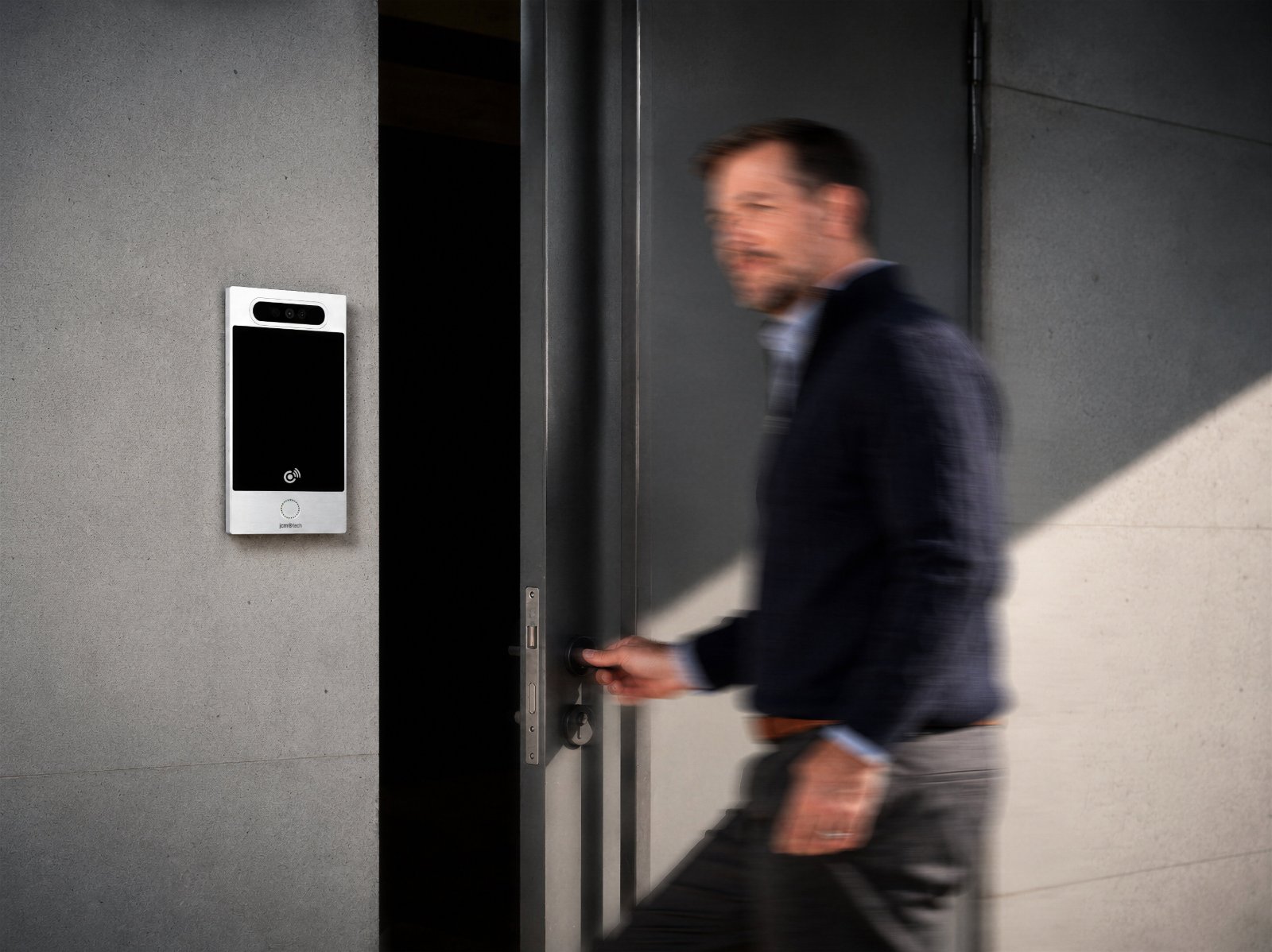 Un residente accede al portal junto a la placa exterior HONOACALL
